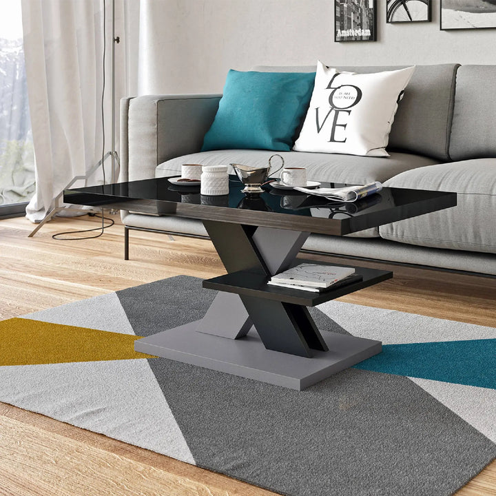 Glossy black coffee table with a grey X-shaped base, styled in a contemporary living room with bold geometric decor.
