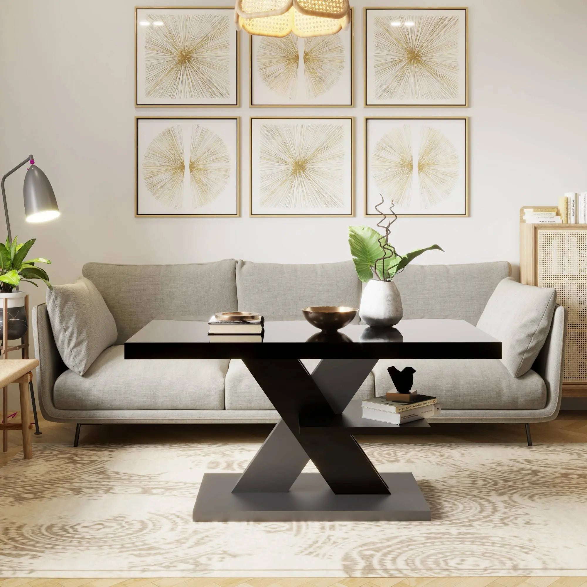A glossy black coffee table with a grey X-shaped base, styled as the centerpiece of a modern living room with gold accents.